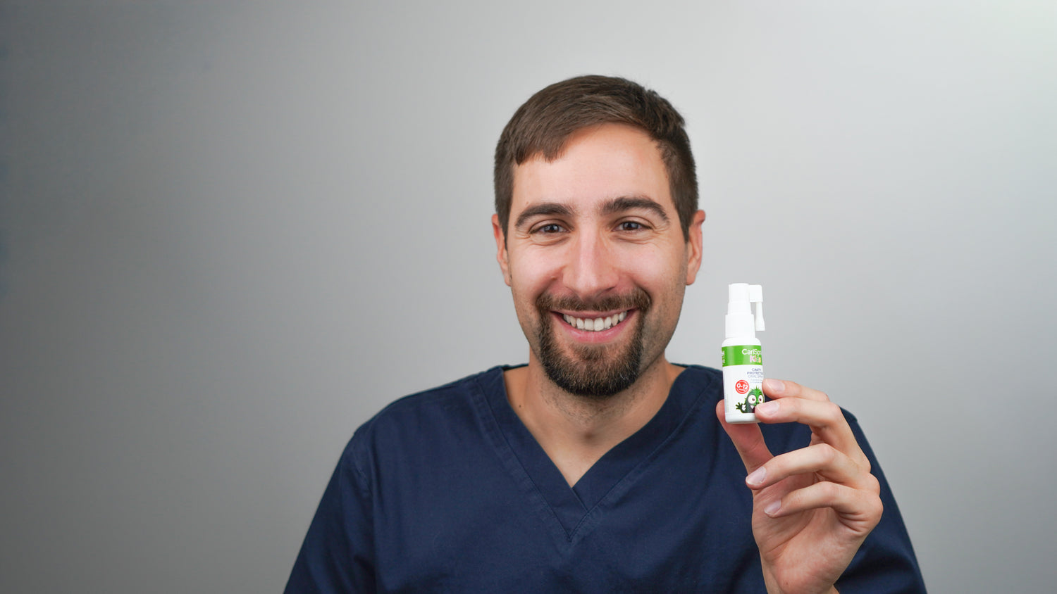 Dr. Toni Martincevic, founder of CariSpray, holding a CariSpray bottle